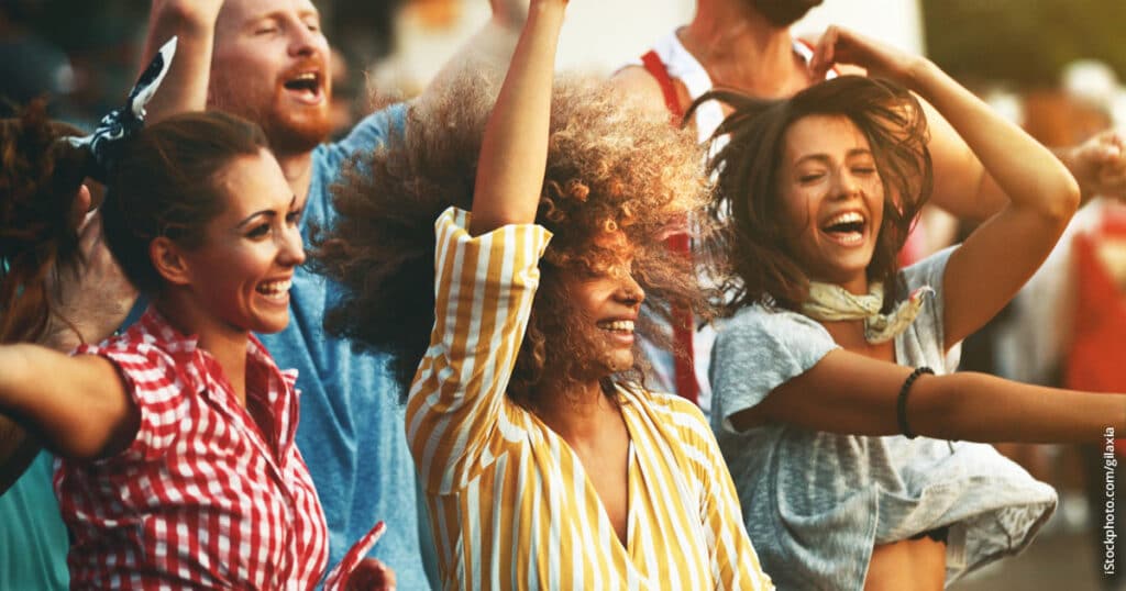 women happily dancing at concert