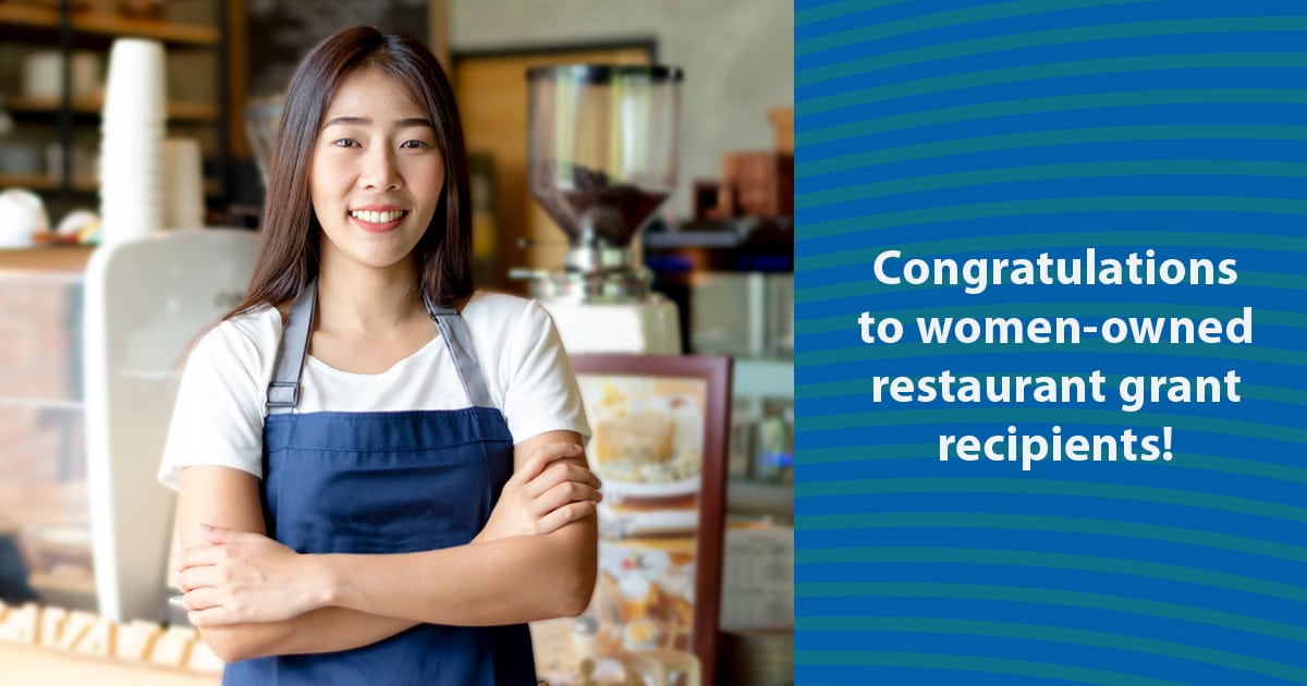 young Asian female cafe owner in front of service counter with message congratulating women-owned restaurant grant recipients