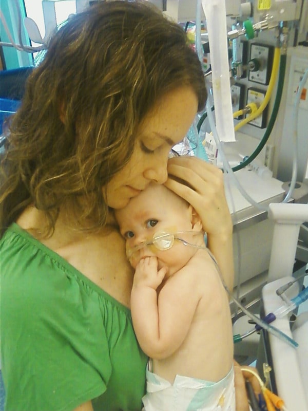 Denise Duclos comforting her sick baby in the hospital