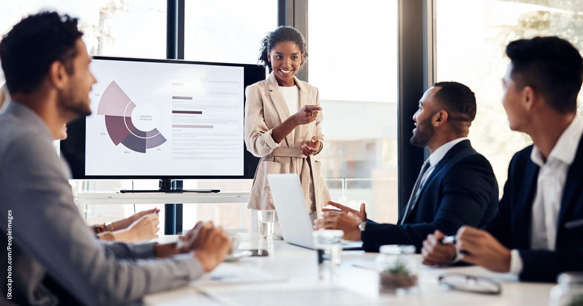 businesswoman delivering presentation to all male colleagues