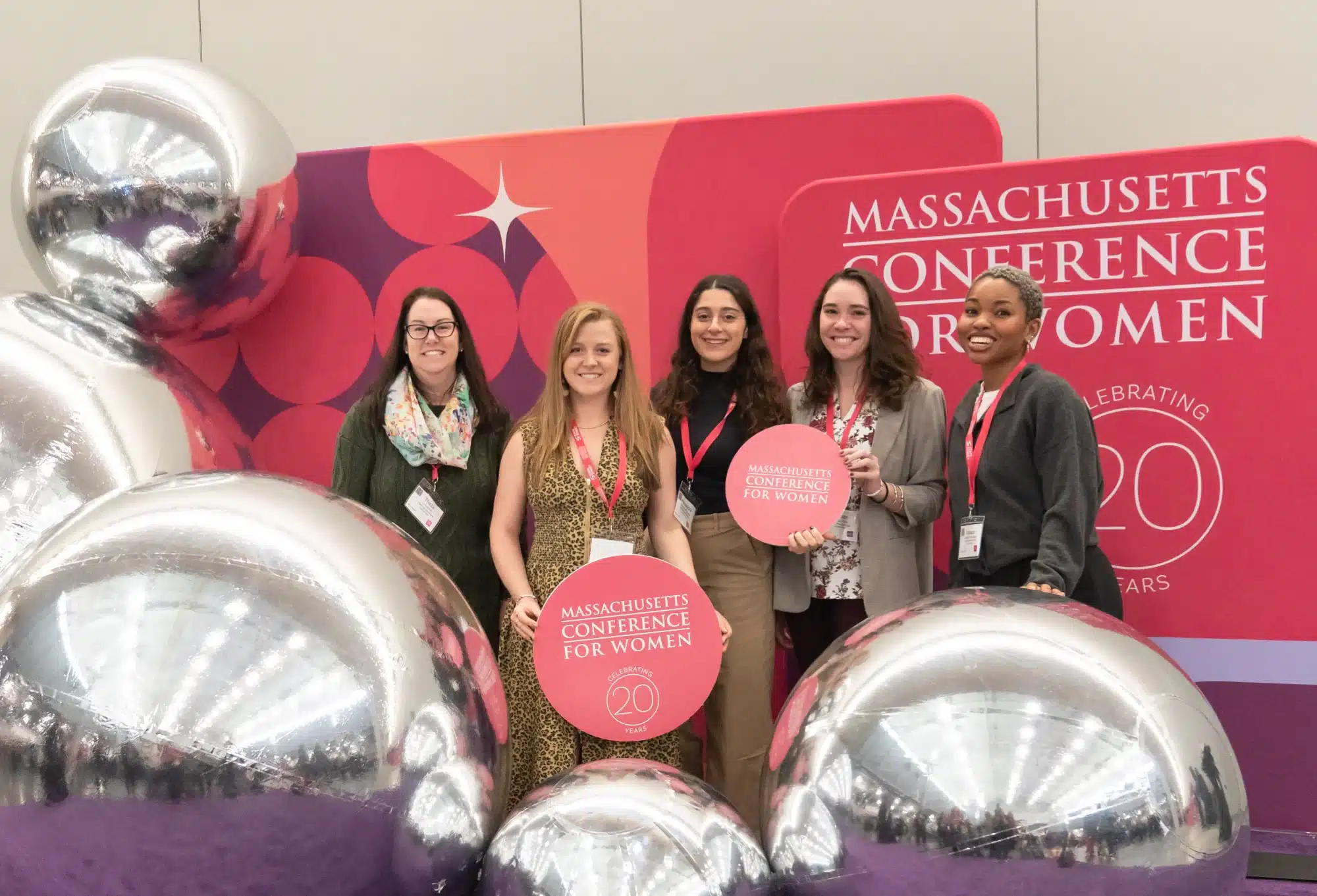 Massachusetts Conference for Women attendees behind giant silver balloon display